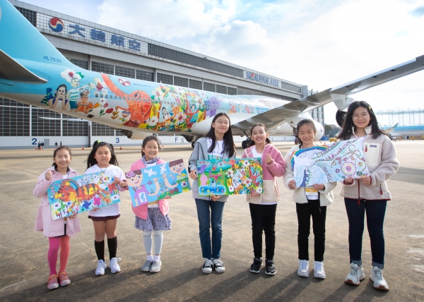 수상 어린이들이 1등 작품이 래핑된 대한항공 보잉 747-8i 항공기 앞에서 기념 사진